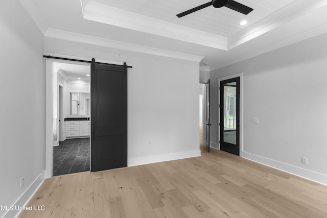 231 Oakside Trl, Madison, MS 39110 - unfurnished bedroom featuring a tray ceiling, a barn door, light wood-style floors, baseboards, and recessed lighting