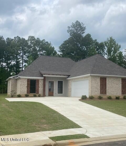 view of front of house featuring a garage and a front lawn