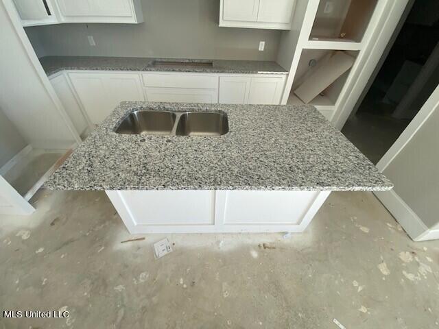 kitchen with light stone counters and white cabinets