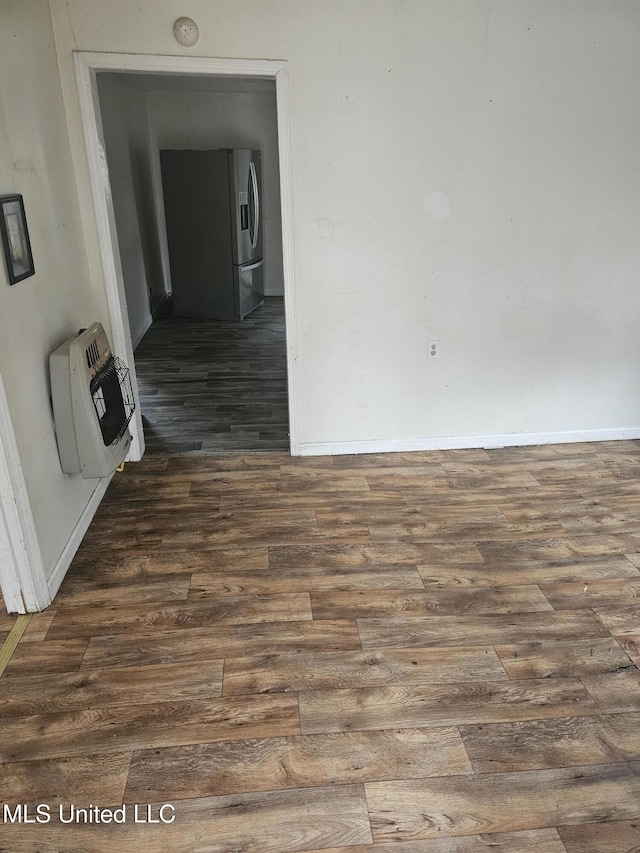 219 W St, Batesville, MS 38606 - empty room featuring dark wood-type flooring, baseboards, and heating unit