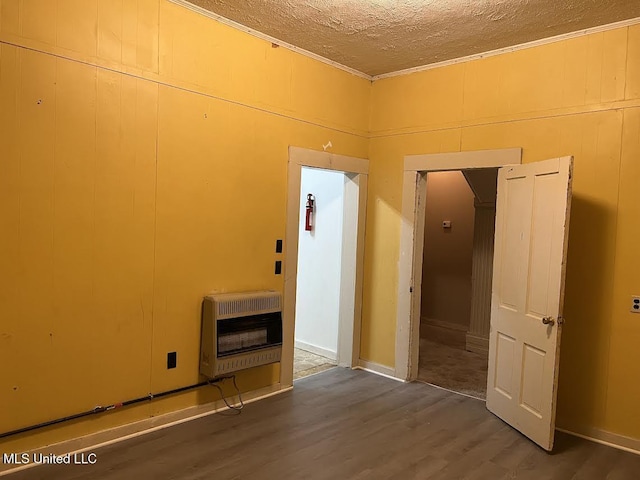 interior space featuring a textured ceiling, heating unit, and dark hardwood / wood-style floors