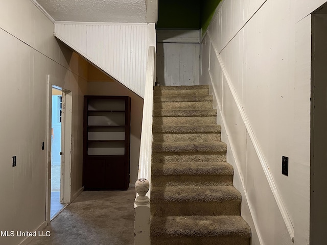 stairway with a textured ceiling