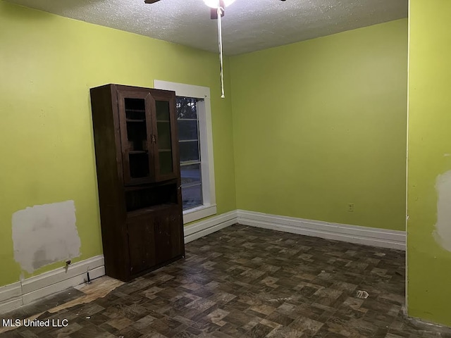 empty room featuring ceiling fan and a textured ceiling