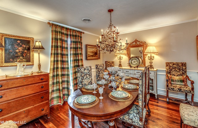 dining room with an inviting chandelier, crown molding, and hardwood / wood-style flooring