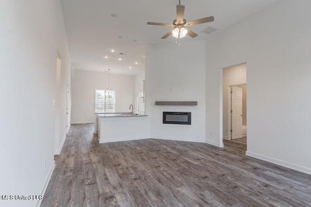 unfurnished living room with ceiling fan and dark hardwood / wood-style floors