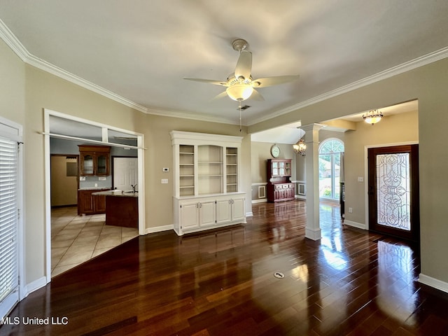 interior space featuring wood finished floors, crown molding, ornate columns, and ceiling fan with notable chandelier