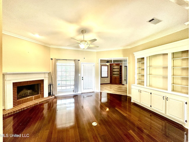 unfurnished living room with a fireplace, visible vents, dark wood-style flooring, baseboards, and ceiling fan