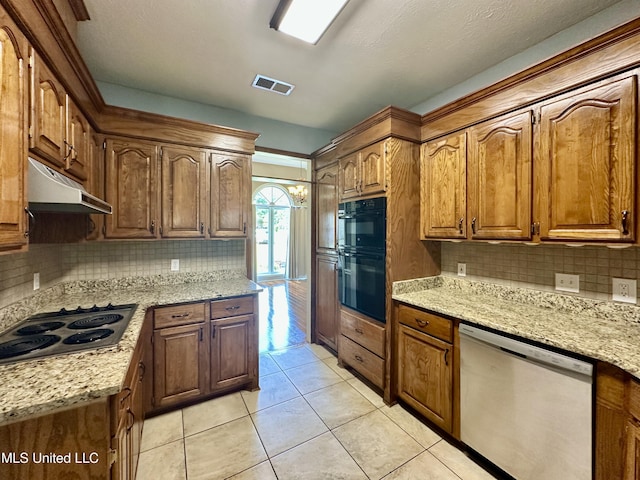 kitchen with tasteful backsplash, visible vents, under cabinet range hood, light tile patterned floors, and appliances with stainless steel finishes