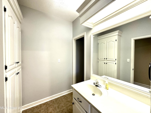 bathroom with vanity, baseboards, and tile patterned floors