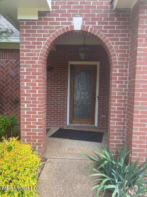 view of exterior entry featuring brick siding