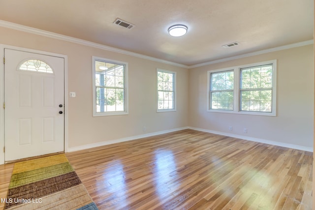 foyer with ornamental molding and light wood-type flooring