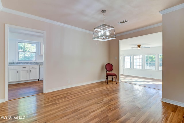 empty room with crown molding, ceiling fan with notable chandelier, and light wood-type flooring