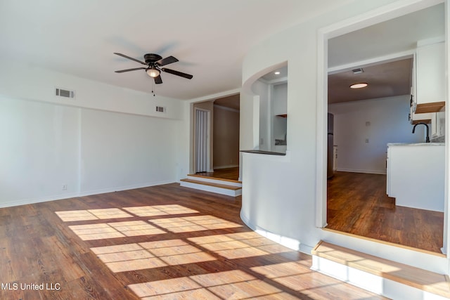 unfurnished room featuring hardwood / wood-style flooring, sink, and ceiling fan