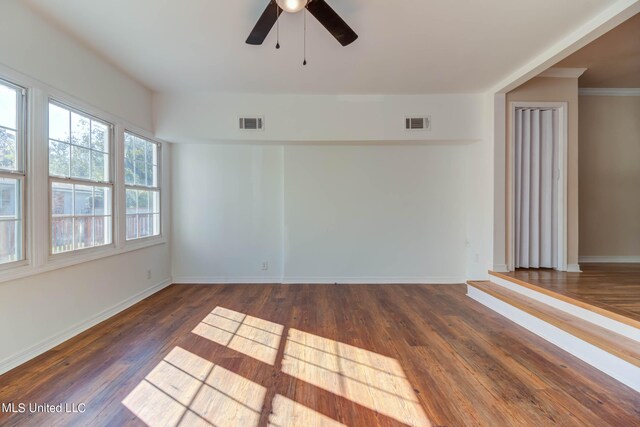 unfurnished room with crown molding, dark hardwood / wood-style floors, and ceiling fan