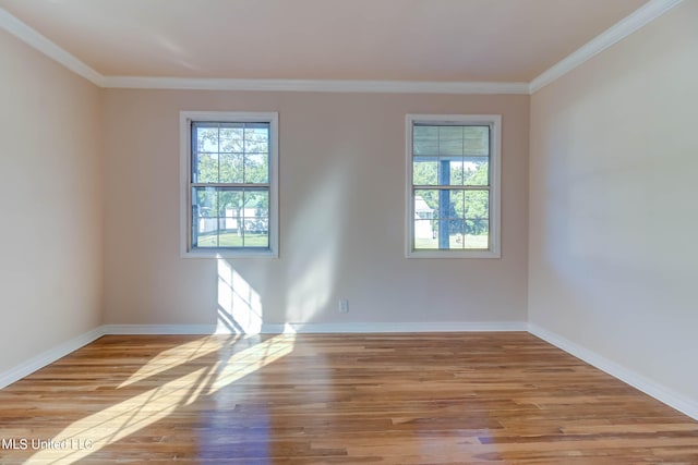 spare room featuring crown molding and light hardwood / wood-style floors