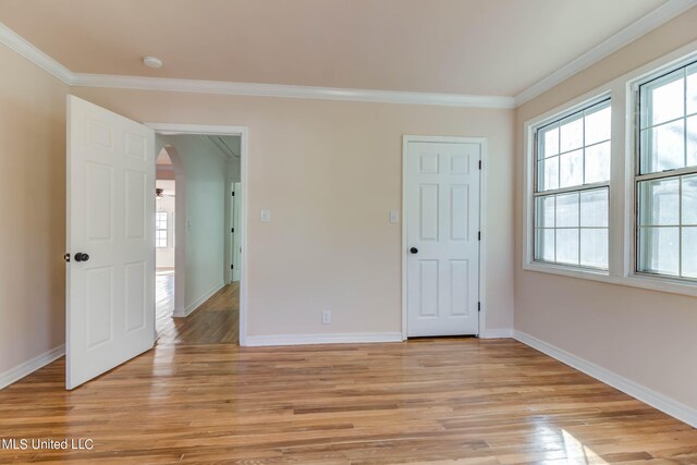 spare room featuring light hardwood / wood-style floors and ornamental molding