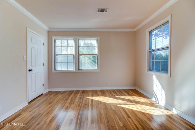 spare room with crown molding and light hardwood / wood-style floors