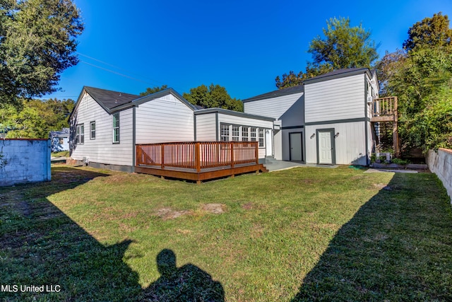 rear view of property with a wooden deck, a shed, and a lawn