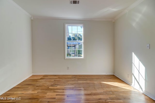 spare room with light hardwood / wood-style flooring and crown molding