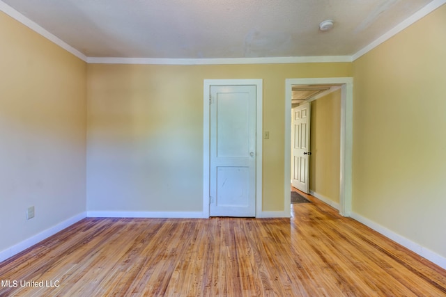 unfurnished room featuring ornamental molding and light wood-type flooring