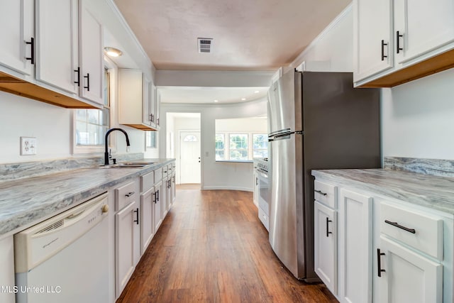 kitchen with sink, dishwasher, white cabinetry, and dark hardwood / wood-style flooring