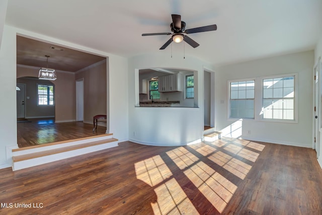 258 Porter Ave, Biloxi, MS 39530 - unfurnished living room featuring arched walkways, baseboards, a ceiling fan, crown molding, and dark wood-type flooring