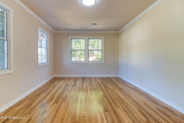 spare room with crown molding and light wood-type flooring