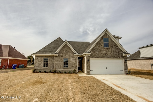 view of front of house featuring a garage and cooling unit