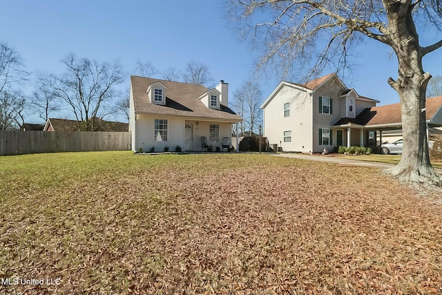 view of front facade with fence, a chimney, and a front lawn