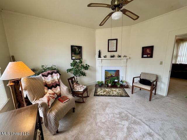 carpeted living room featuring ceiling fan and crown molding