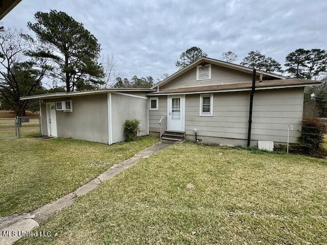 rear view of house featuring a yard