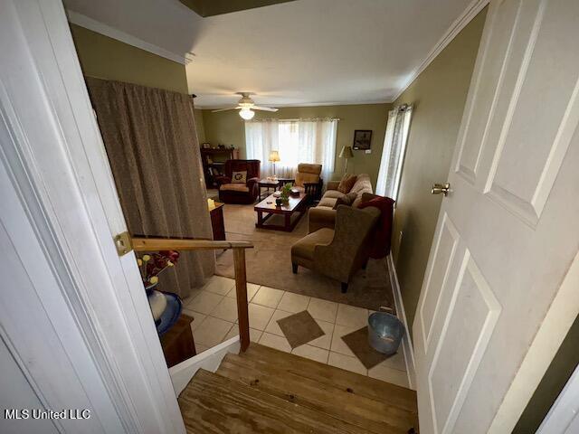 living room with ceiling fan, ornamental molding, and tile patterned flooring