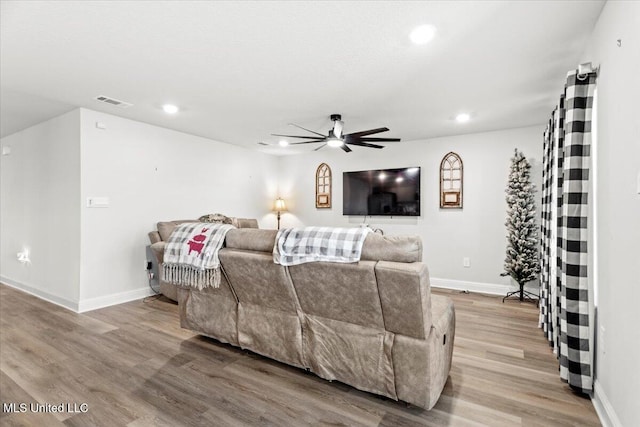 living room with a ceiling fan, visible vents, wood finished floors, baseboards, and recessed lighting