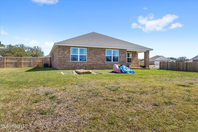 rear view of property with brick siding, a lawn, cooling unit, and fence