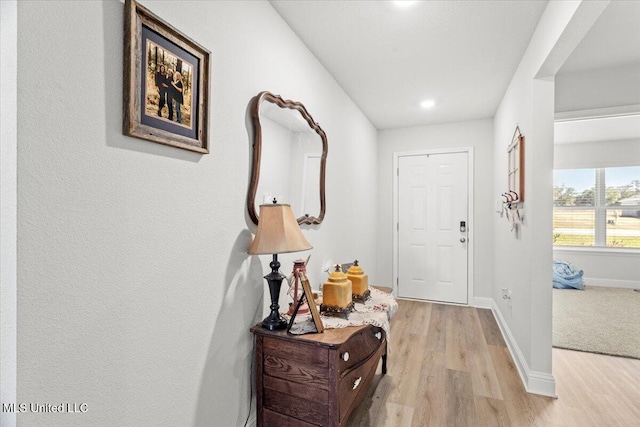 doorway to outside with baseboards and light wood-style floors