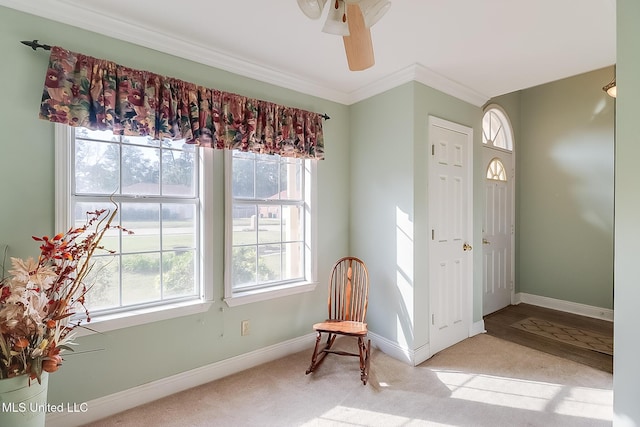 foyer with a healthy amount of sunlight, crown molding, and light colored carpet