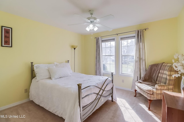 bedroom with light carpet, ceiling fan, and baseboards