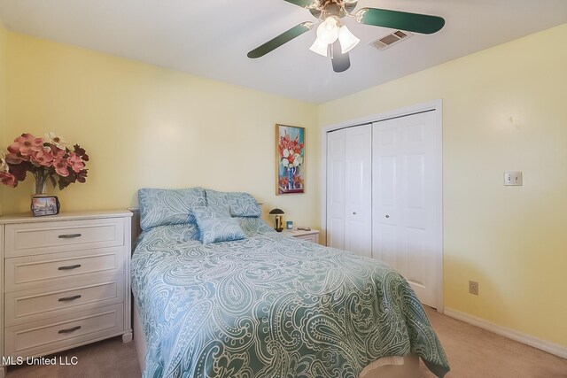 bedroom with ceiling fan, light carpet, visible vents, baseboards, and a closet