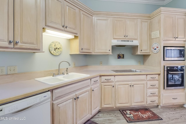 kitchen with appliances with stainless steel finishes, light countertops, a sink, and under cabinet range hood