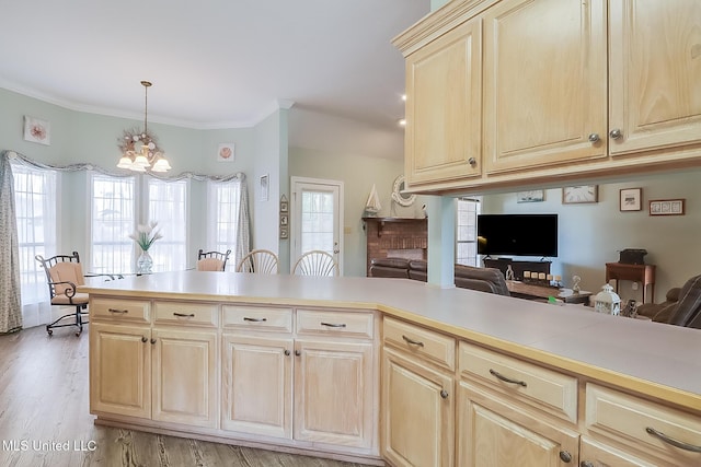 kitchen with open floor plan, light countertops, hanging light fixtures, and a peninsula