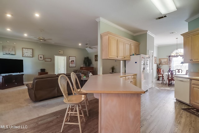 kitchen featuring white appliances, a kitchen bar, open floor plan, and light countertops