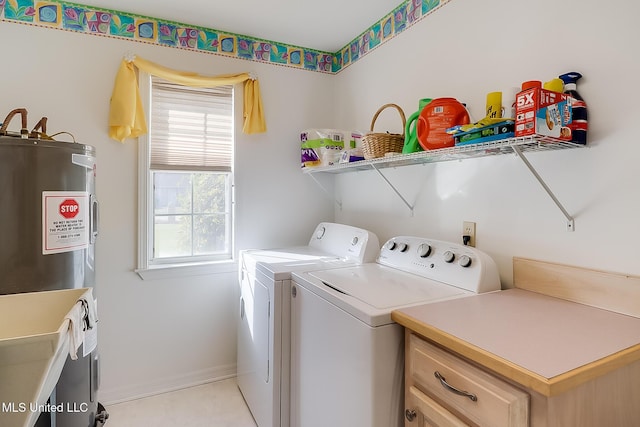 clothes washing area featuring water heater, washing machine and clothes dryer, and baseboards