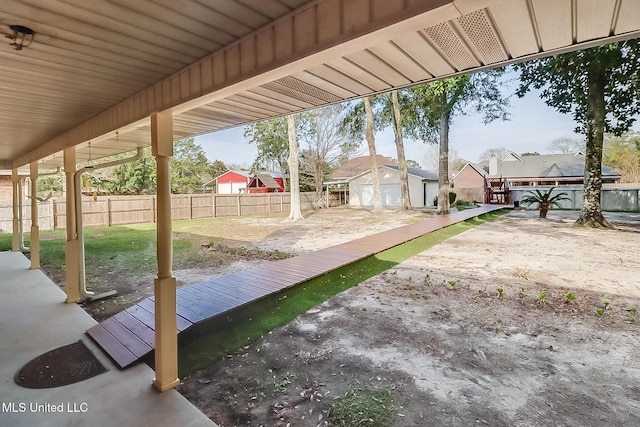 view of patio / terrace featuring an outdoor structure, fence, and a residential view