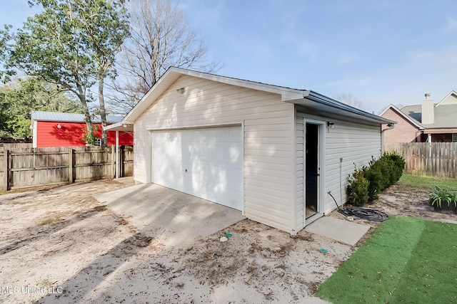 detached garage with driveway and fence