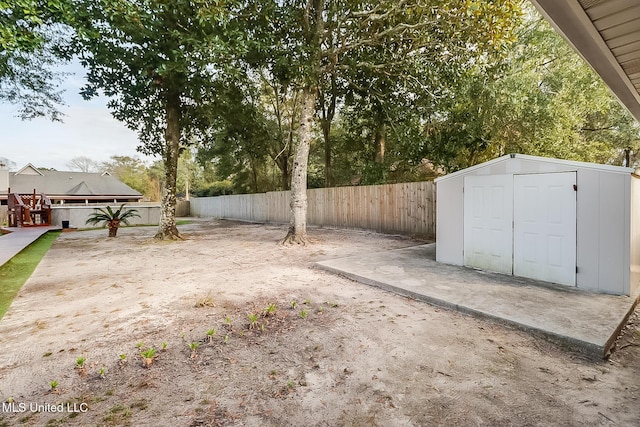 view of yard featuring an outbuilding, a storage unit, and a fenced backyard