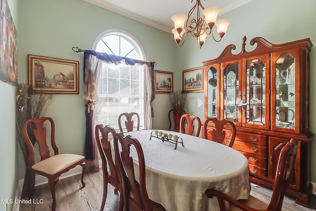 dining space featuring a notable chandelier, crown molding, and wood finished floors