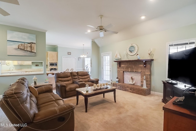 living room featuring light colored carpet, lofted ceiling, ceiling fan, crown molding, and a brick fireplace