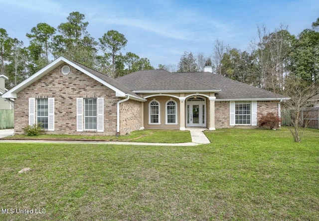 ranch-style home with brick siding, fence, a front yard, roof with shingles, and a chimney