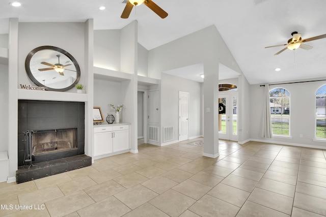 unfurnished living room featuring visible vents, a fireplace, baseboards, and ceiling fan