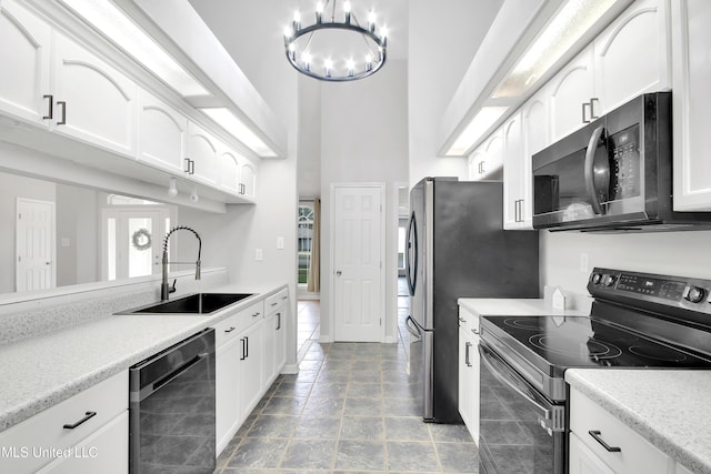 kitchen featuring stainless steel electric stove, dishwashing machine, an inviting chandelier, white cabinets, and a sink